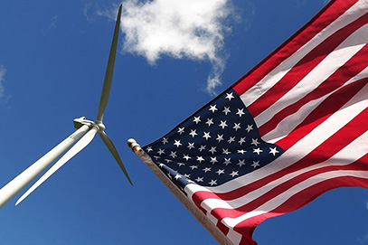 A wind turbine next to an American flag.