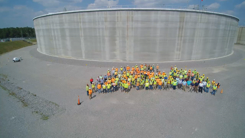 Saltstone Disposal Unit 8 project team members stand in front of the newest mega-size disposal unit completed at the Savannah River Site.