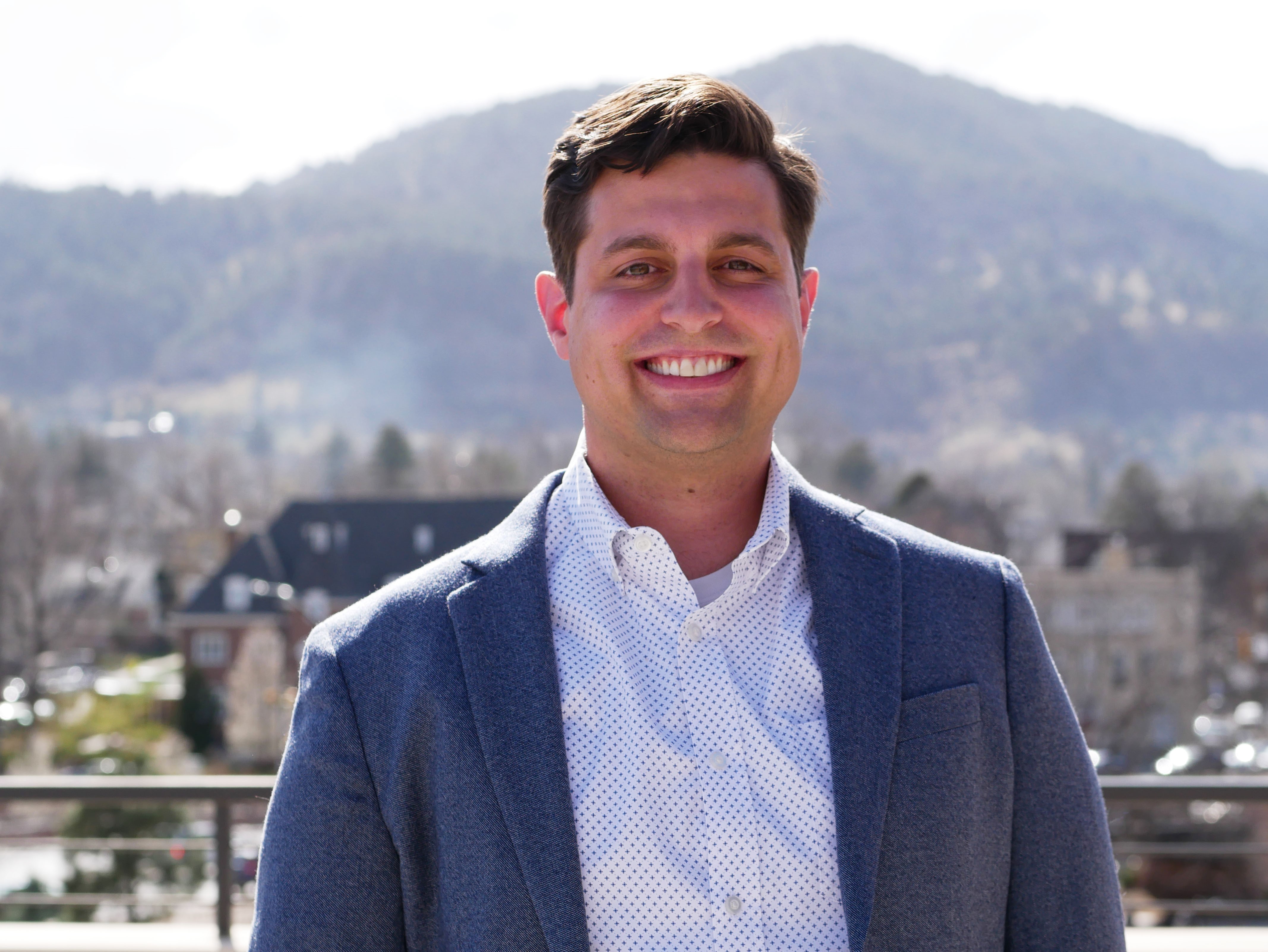 Head-and-shoulders photo of Kyle Biega, with mountains showing behind him.