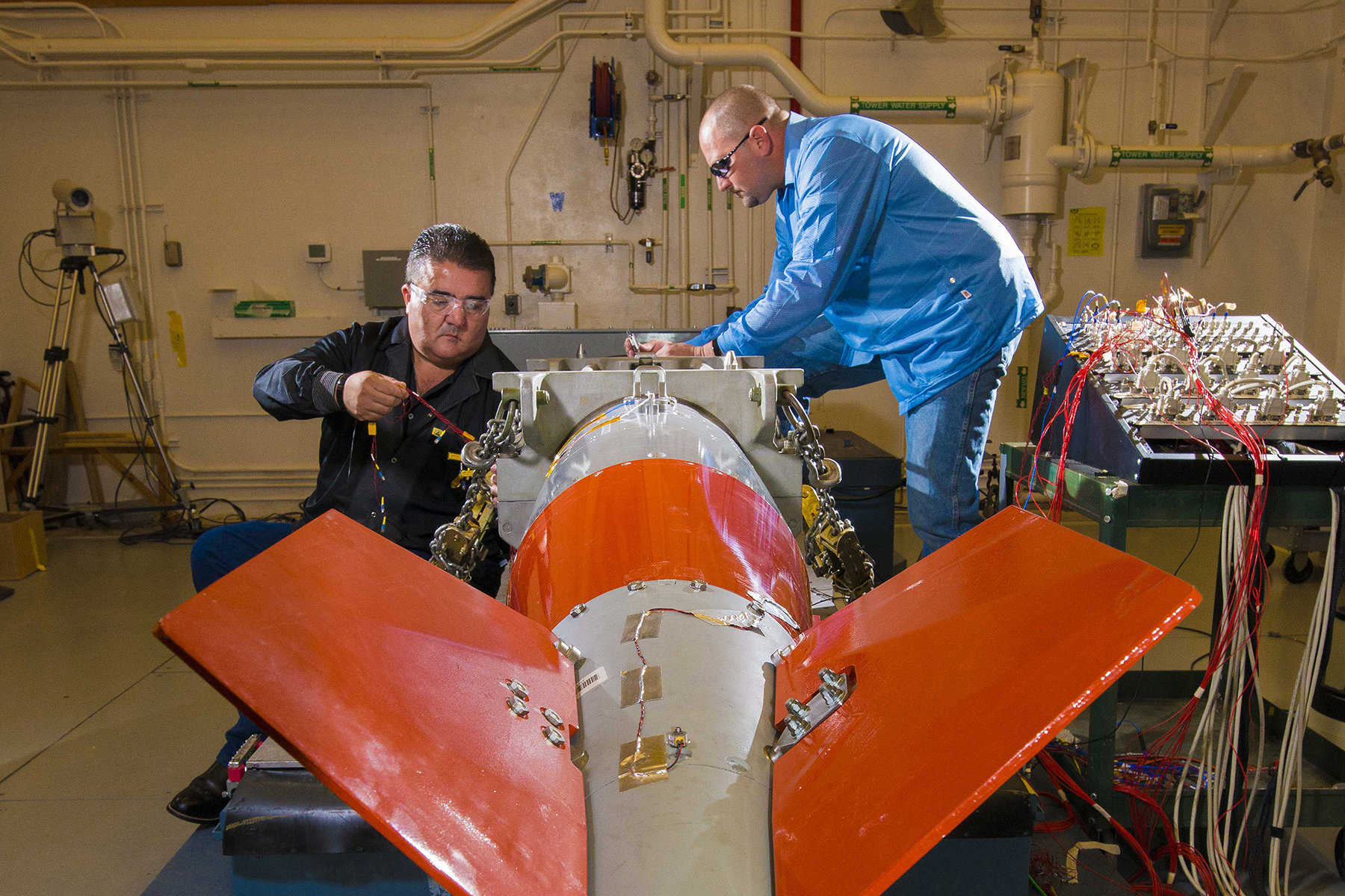 Two technicians working on the B61 in the vibration shock lab