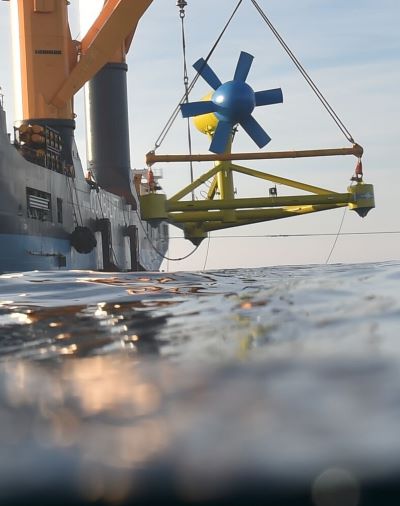 A ship releasing a marine energy device into the ocean