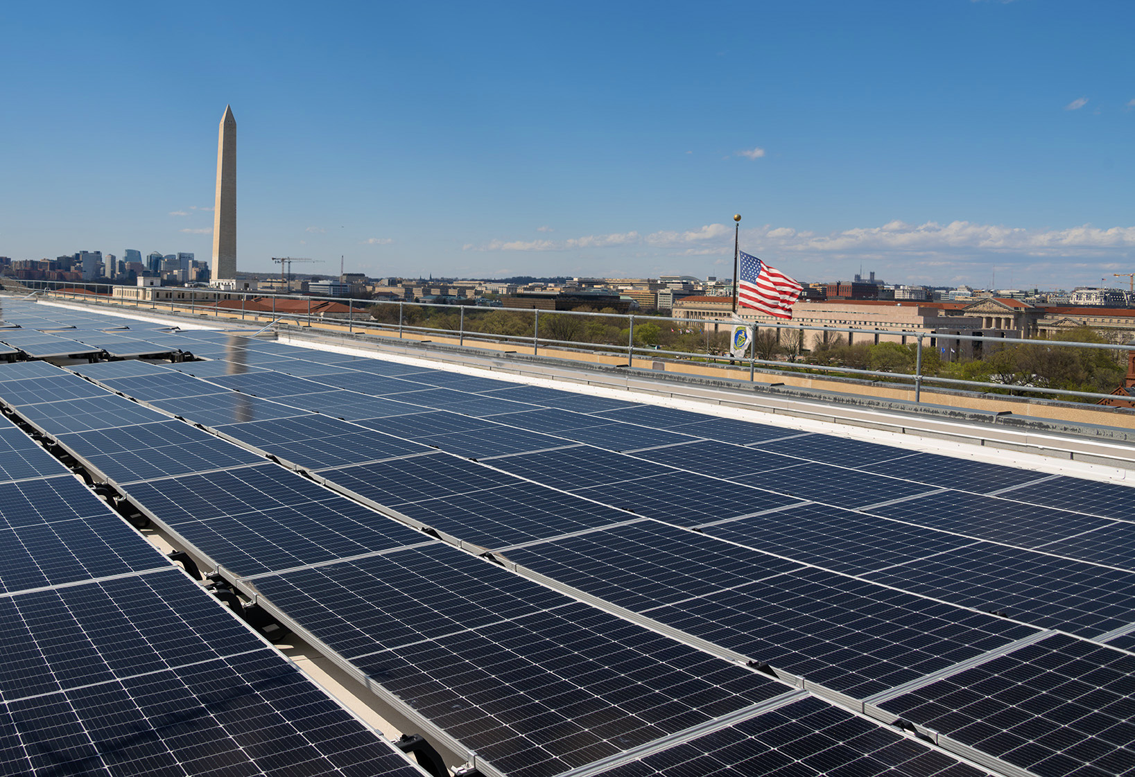 Image of solar panels on a roof with the Washington Monument in the background