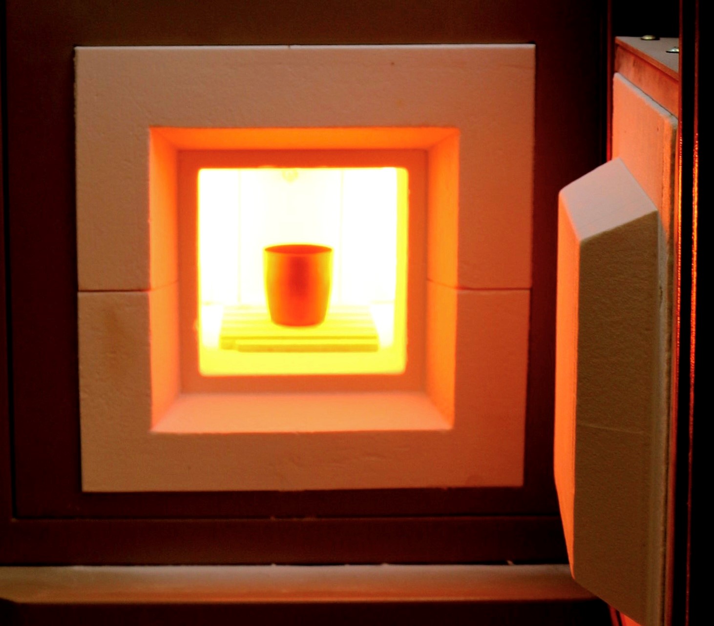 An orange glowing box with a dark cup inside of it