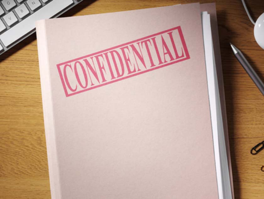 Folder stamped CONFIDENTIAL on a desk