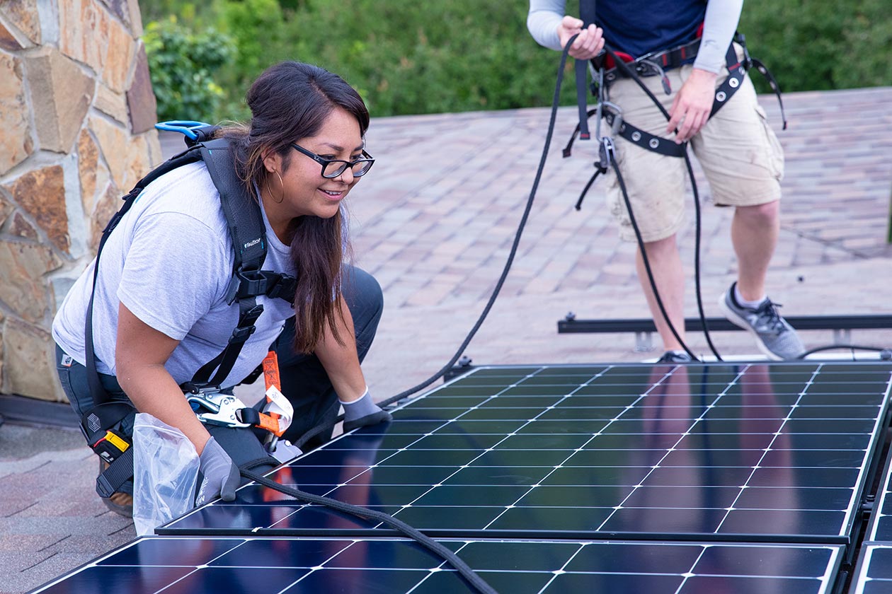 A woman works on a solar panel.