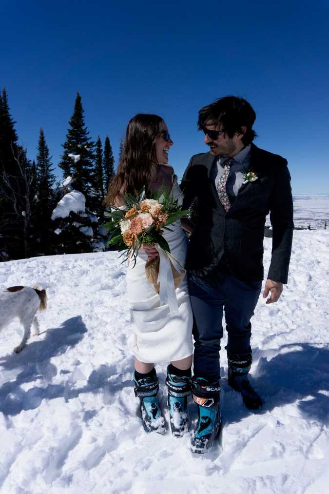 Gallego-Calderon and his wife wearing wedding attire and ski boots while standing on snow 