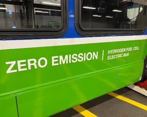 Lettering on the side of a city bus says "Zero Emission Hydrogen Fuel Cell Electric Bus"