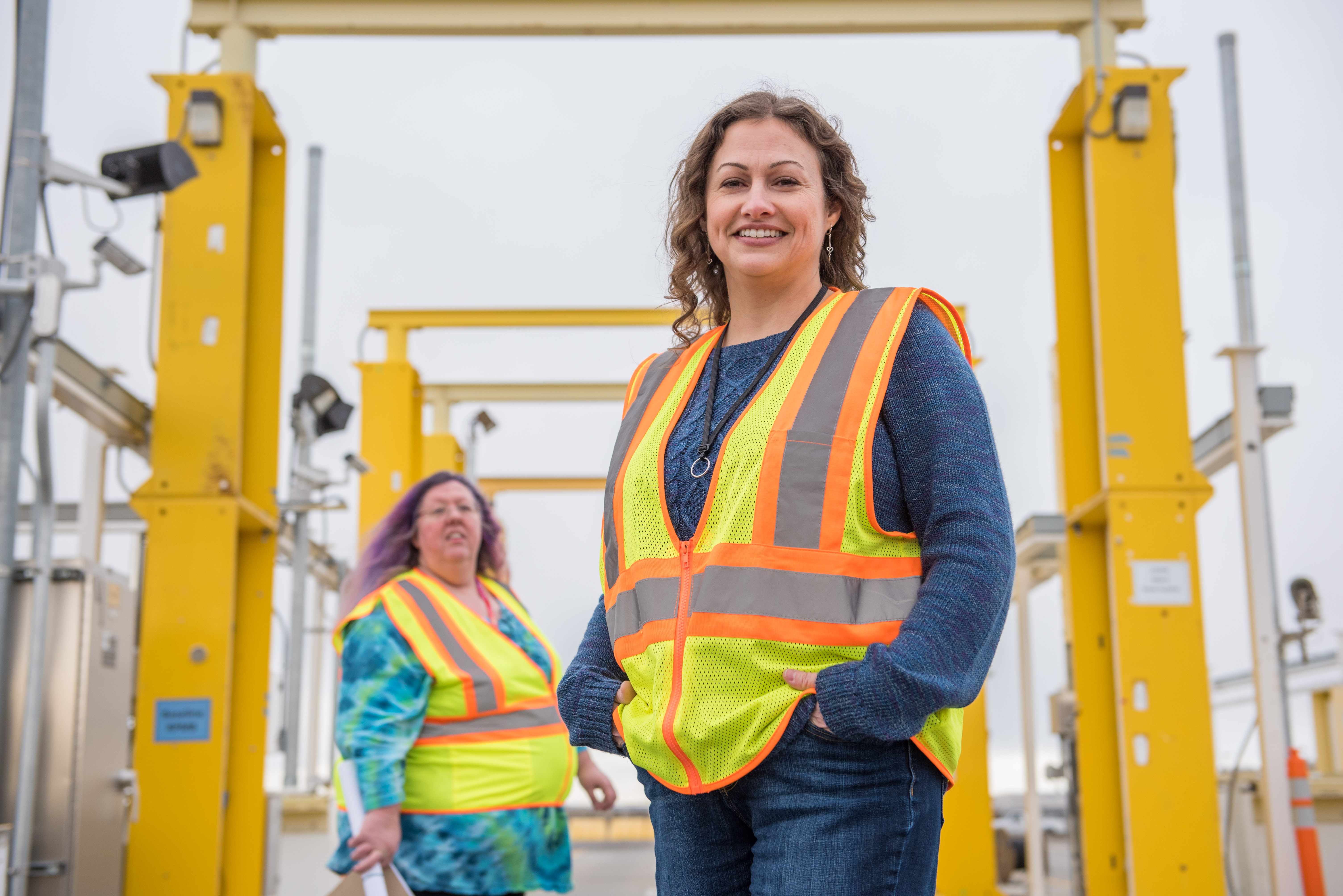 Two women wearing construction vests