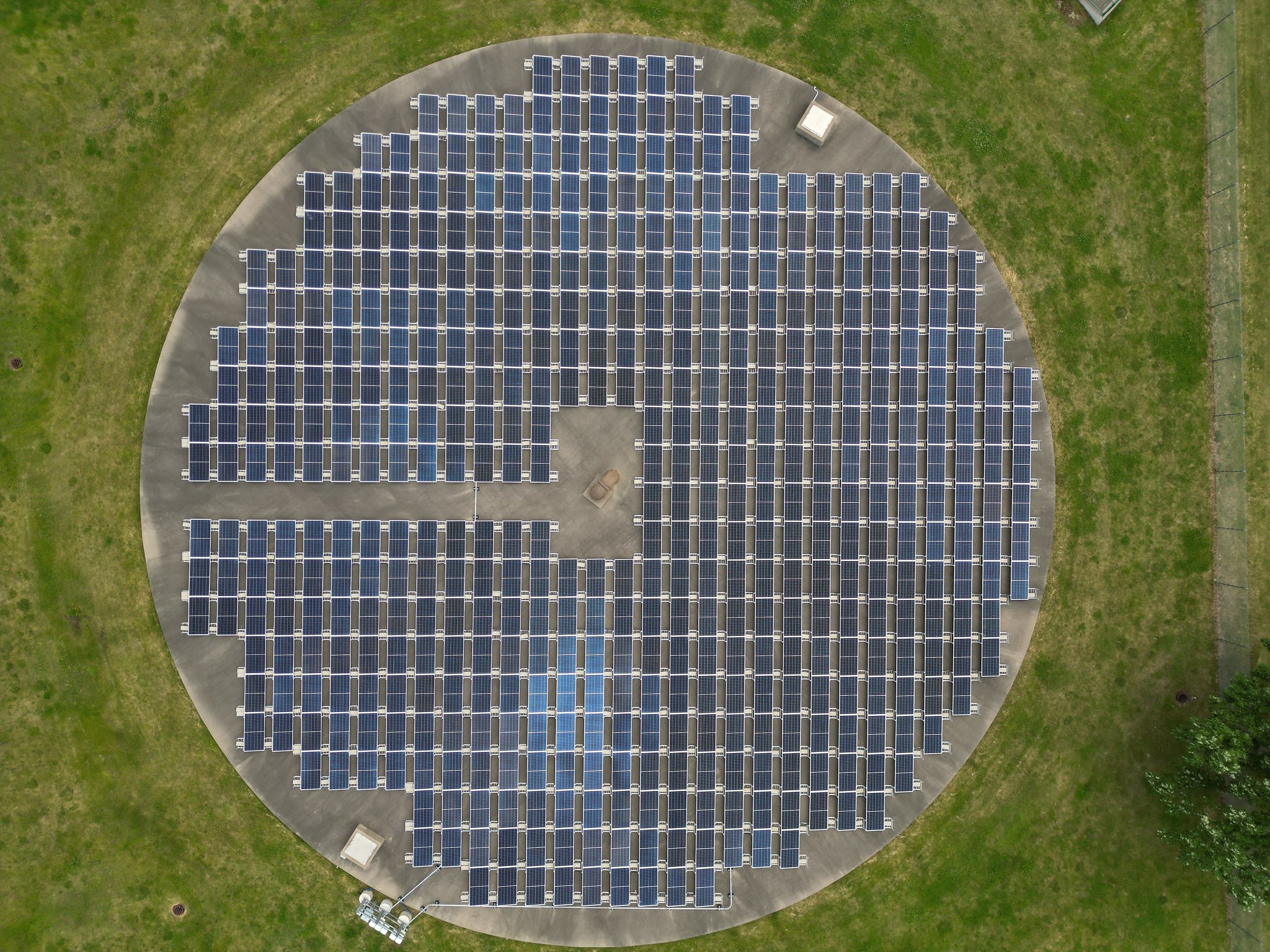 An aerial photo of a solar array built on top of a water treatment tank cover.