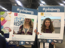 Two girl scouts take pictures with our "girls of energy" instagram boxes