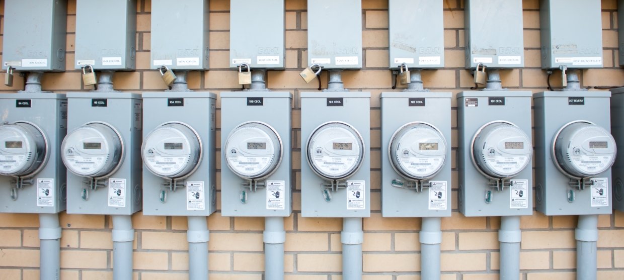 A row of energy meters mounted on the outside of a building.