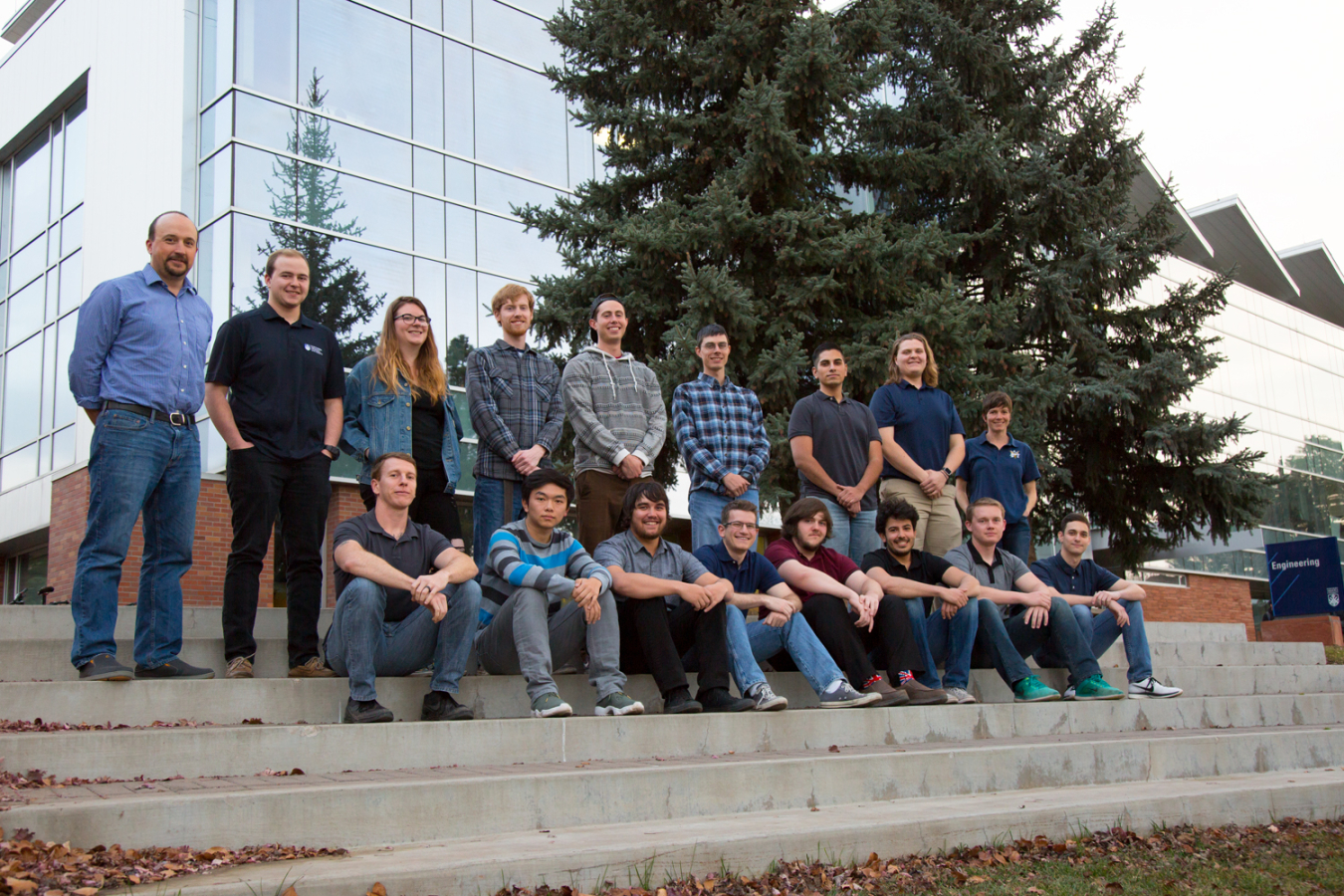 The Northern Arizona University team sits on a step outside of their University.