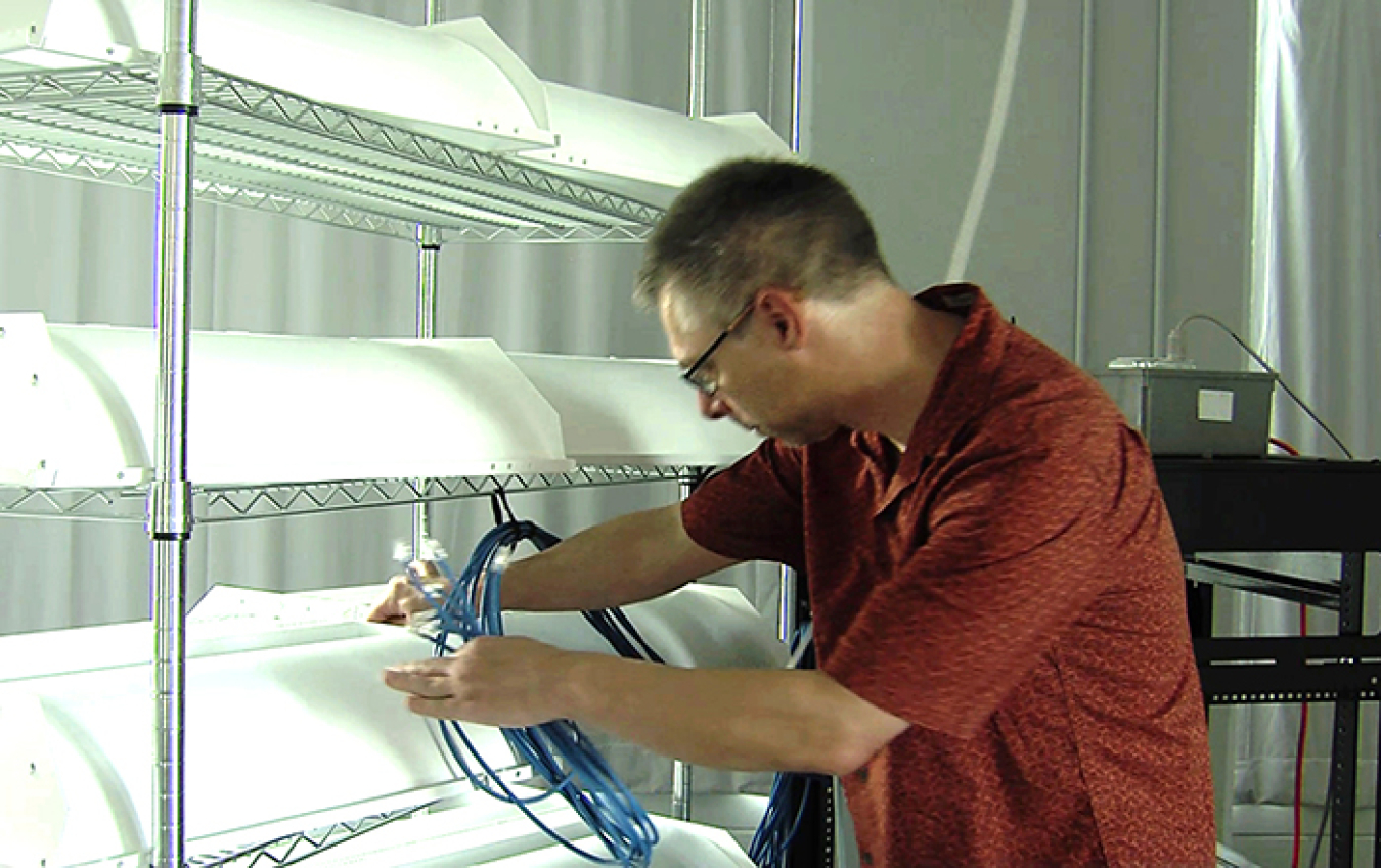 Photo of a man attaching cable to a luminaire.