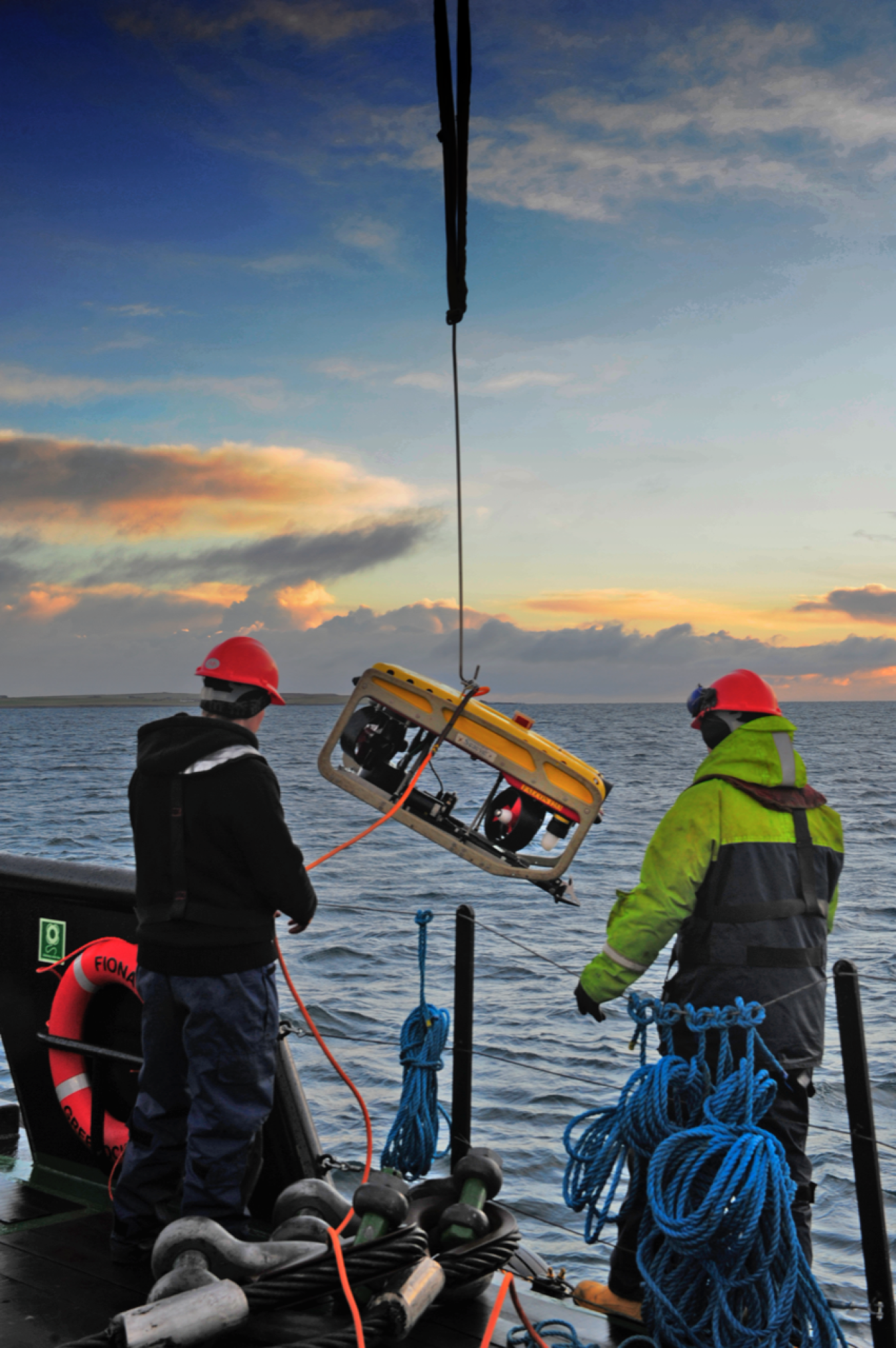 A remotely operated vehicle is lowered into waters.