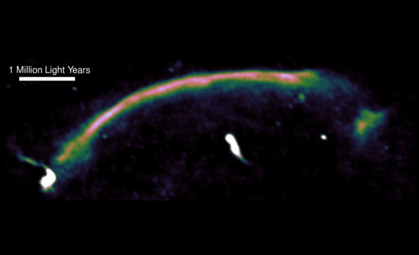 A radio image highlights a shock wave — seen here as the bright arc — in a merging cluster of galaxies.