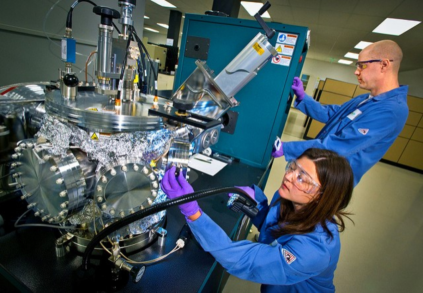 Female and male researchers conduct an experiment related to manufacturing