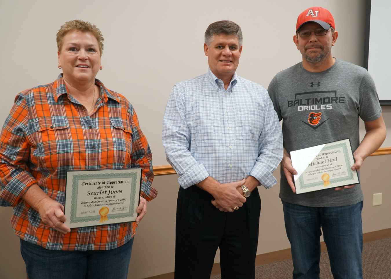 Savannah River Remediation (SRR) President and Project Manager Tom Foster, center, recognizes SRR employees Scarlet Jones, left, and Michael Hall for their willingness to help an SRS employee in a single-vehicle accident. 