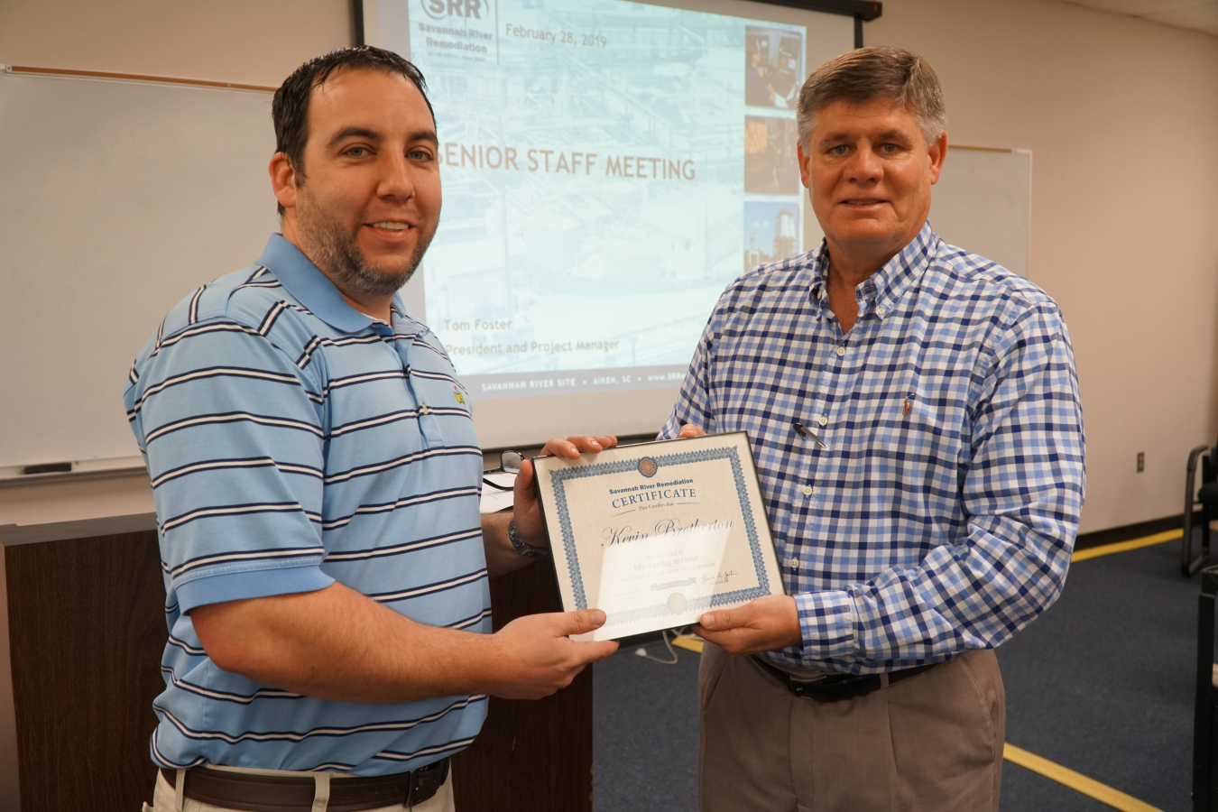 Savannah River Remediation President and Project Manager Tom Foster, right, recognizes SRR Waste Treatment Engineer Kevin Brotherton for his lifesaving actions as a first responder.