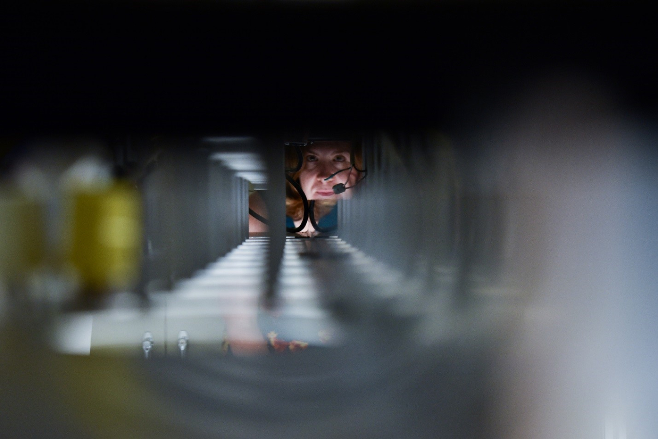 Dr. Karma Sawyer, looking through some equipment that appears as a tunnel in front of her.