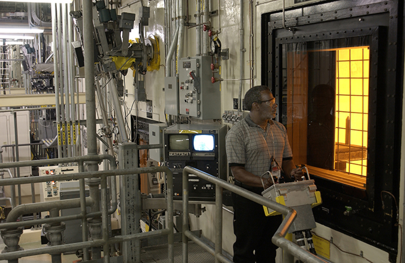     An operator at the Defense Waste Processing Facility maneuvers a canister inside the DWPF canyon via remote controls. All radioactive operations inside DWPF are conducted remotely.