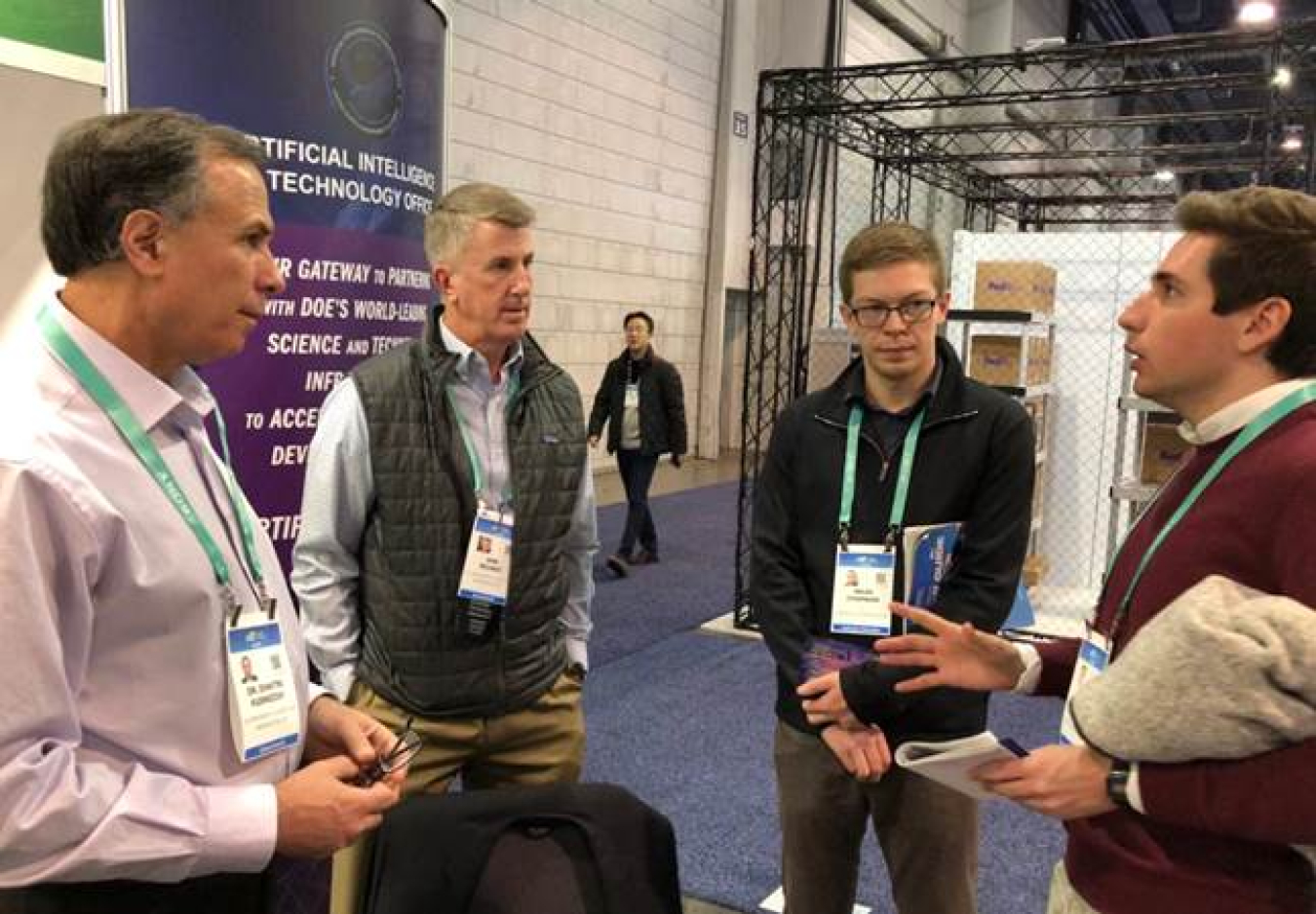 Deputy Under Secretary for Artificial Intelligence and Technology Dimitri Kusnezov and Senior Advisor Dan Wilmot talk with two of the many visitors to the AITO booth at CES 2020.