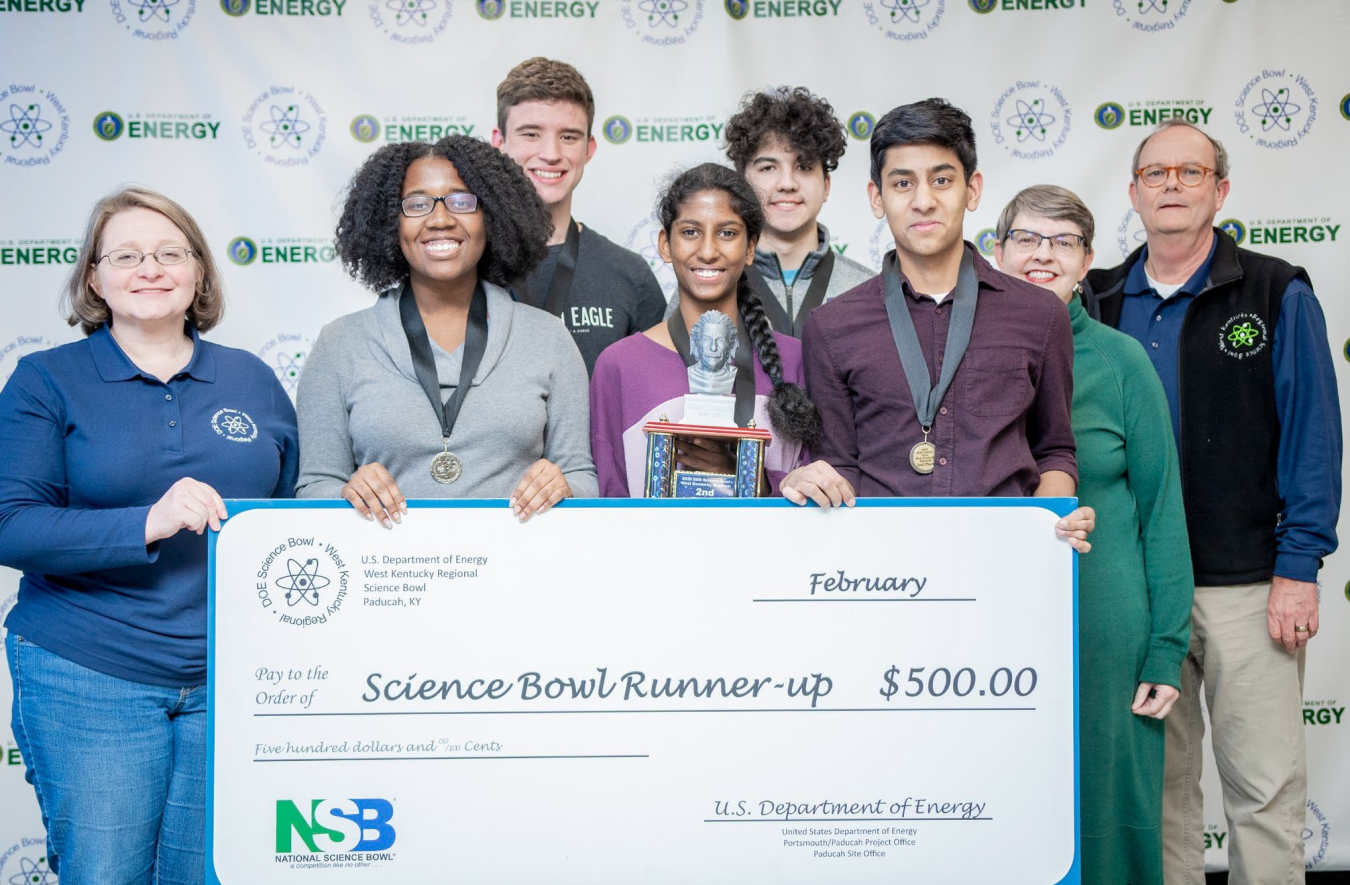 Gatton Team 2 won Second Place. Shown are (l-r): DOE's Jennifer Woodard, Christine Belance, John Domancic, Diksha Satish, Lukas Negron, Ashwin Menon, Coach Cheryl Kirby-Stokes and DOE's Buz Smith.