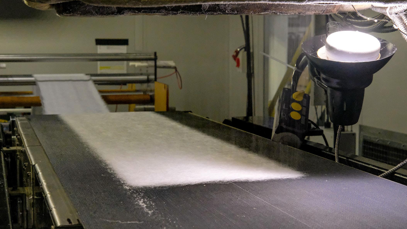 a conveyor belt with mask fabric on it.