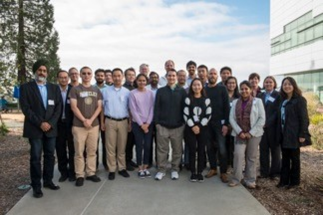 Large group of people standing together outside, looking at the camera.