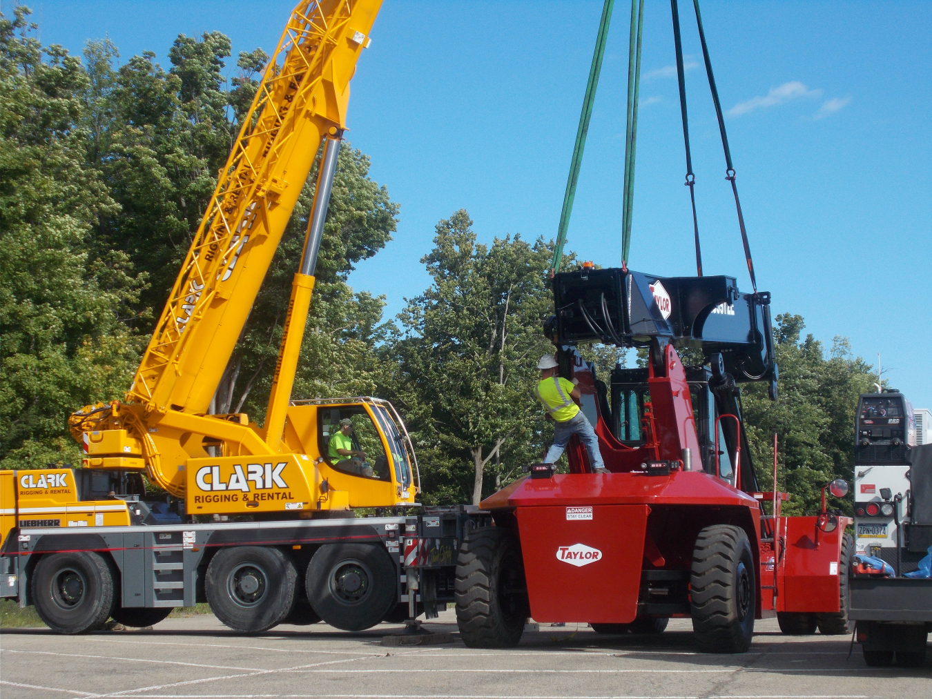 Using a mobile crane, workers install a long-reach arm on a new fork truck for use in waste operations for the future demolition of the Main Plant Process Building at EM's West Valley Demonstration Project.