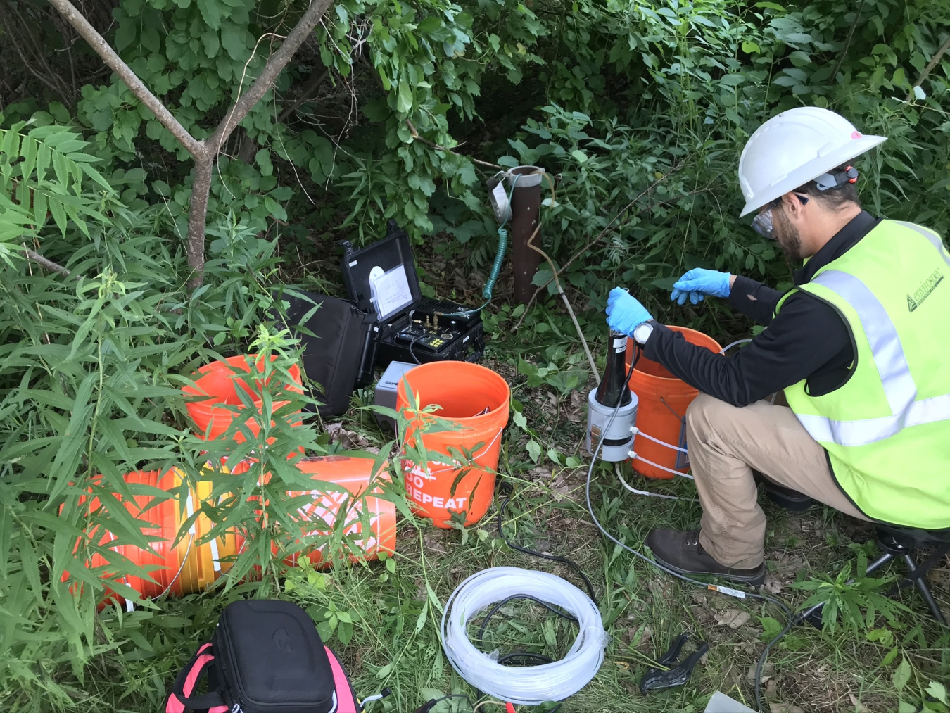 A worker samples groundwater using low-flow sampling protocols.