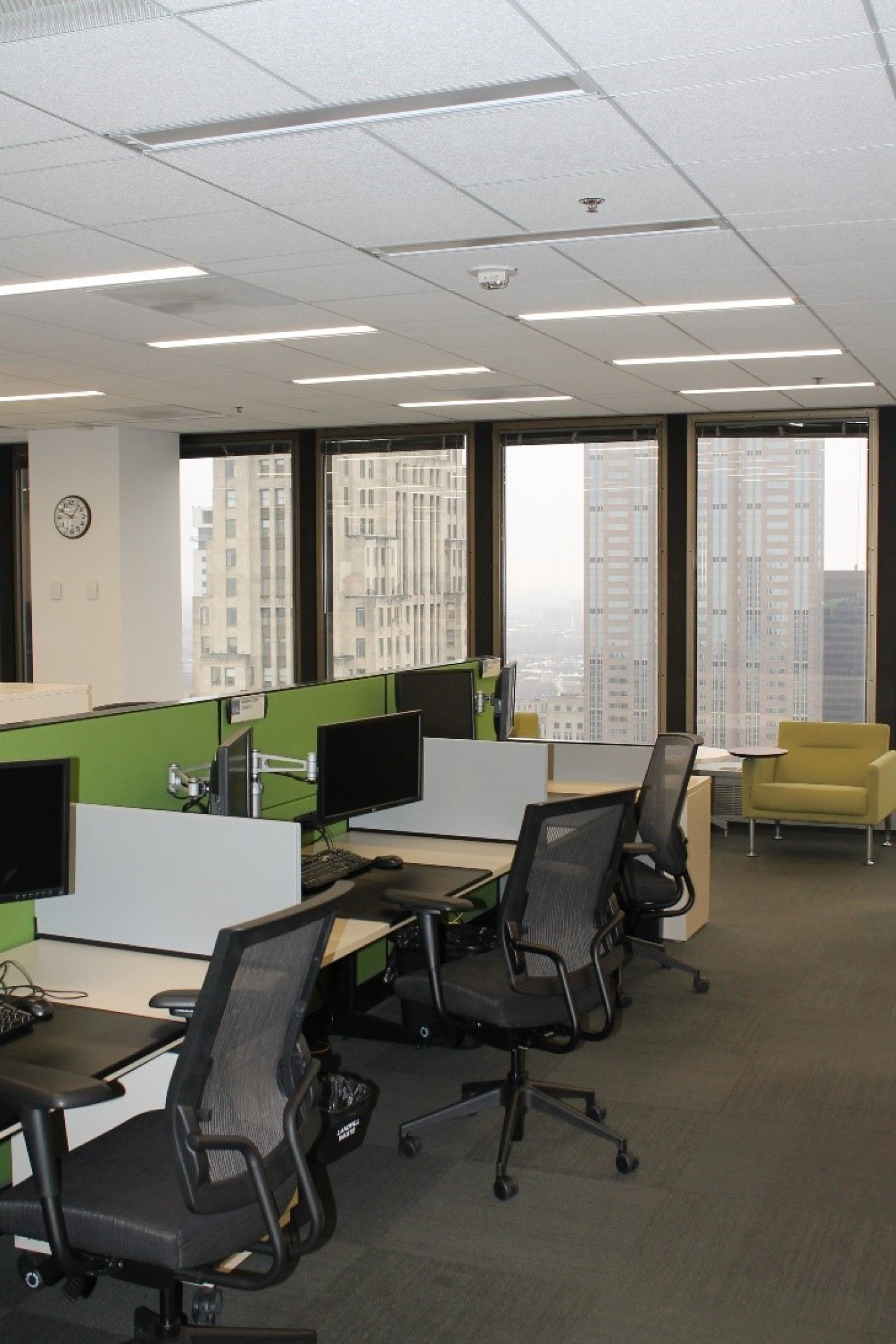 Office building cubicles with integrated lighting above them.