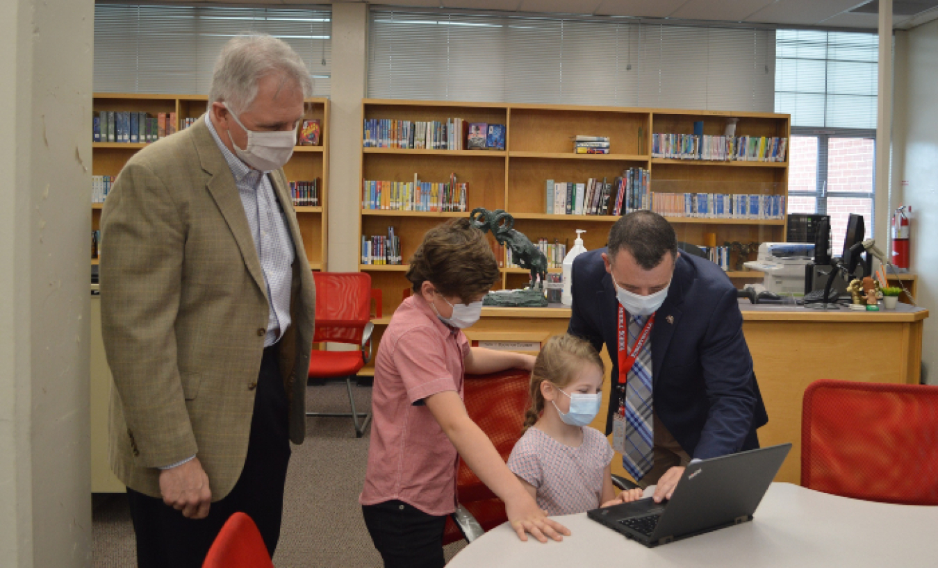 UCOR President and CEO Ken Rueter, left, and Kirk Renegar, an Oak Ridge School District principal, watch as local students use one of 100 new laptops the contractor donated to support virtual learning.