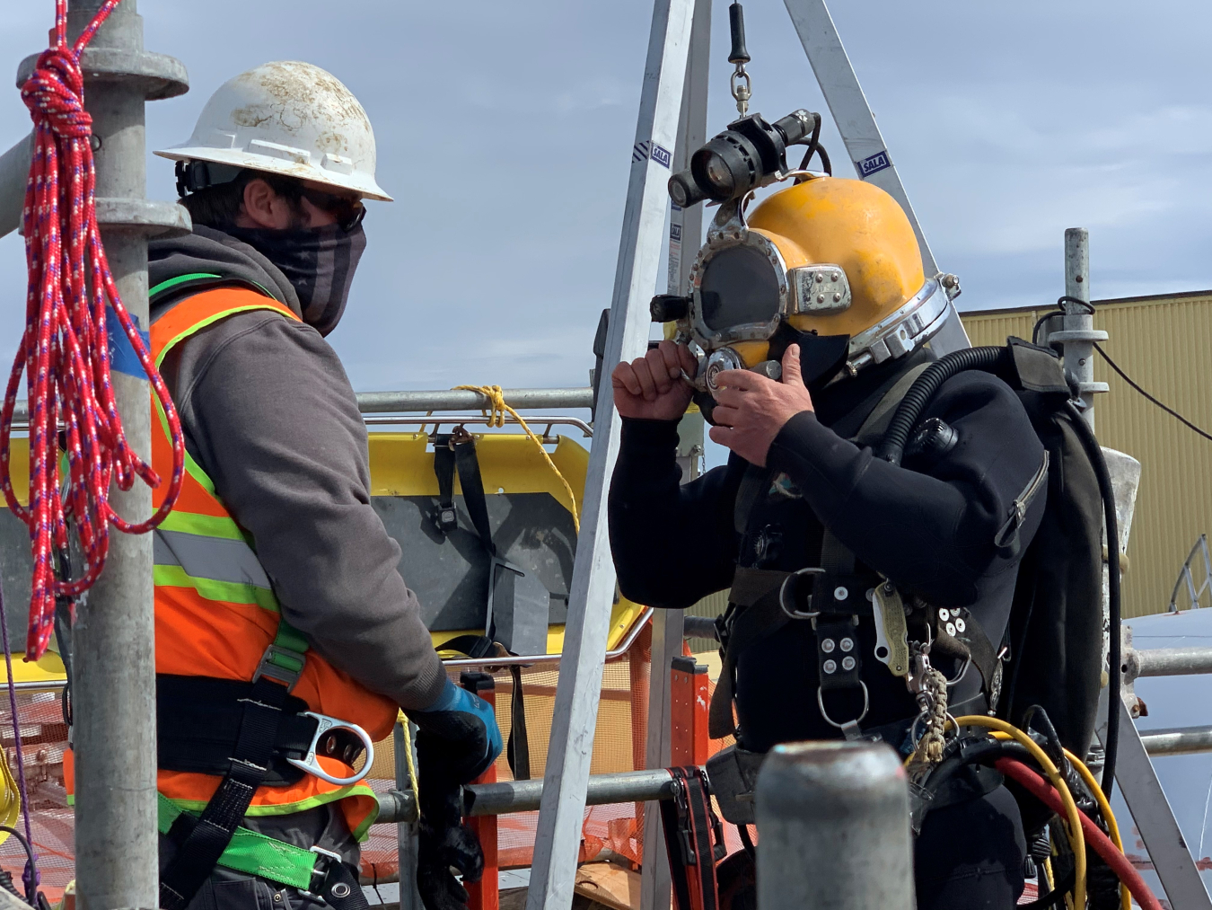 Diver John Lehto, right, receives final instructions from Carter Thomas before entering a 300,000-gallon water tank on the Hanford Site to examine and record current conditions and perform routine maintenance. Lehto and Thomas are employees of Hanford Site subcontractor Associated Underwater Services.