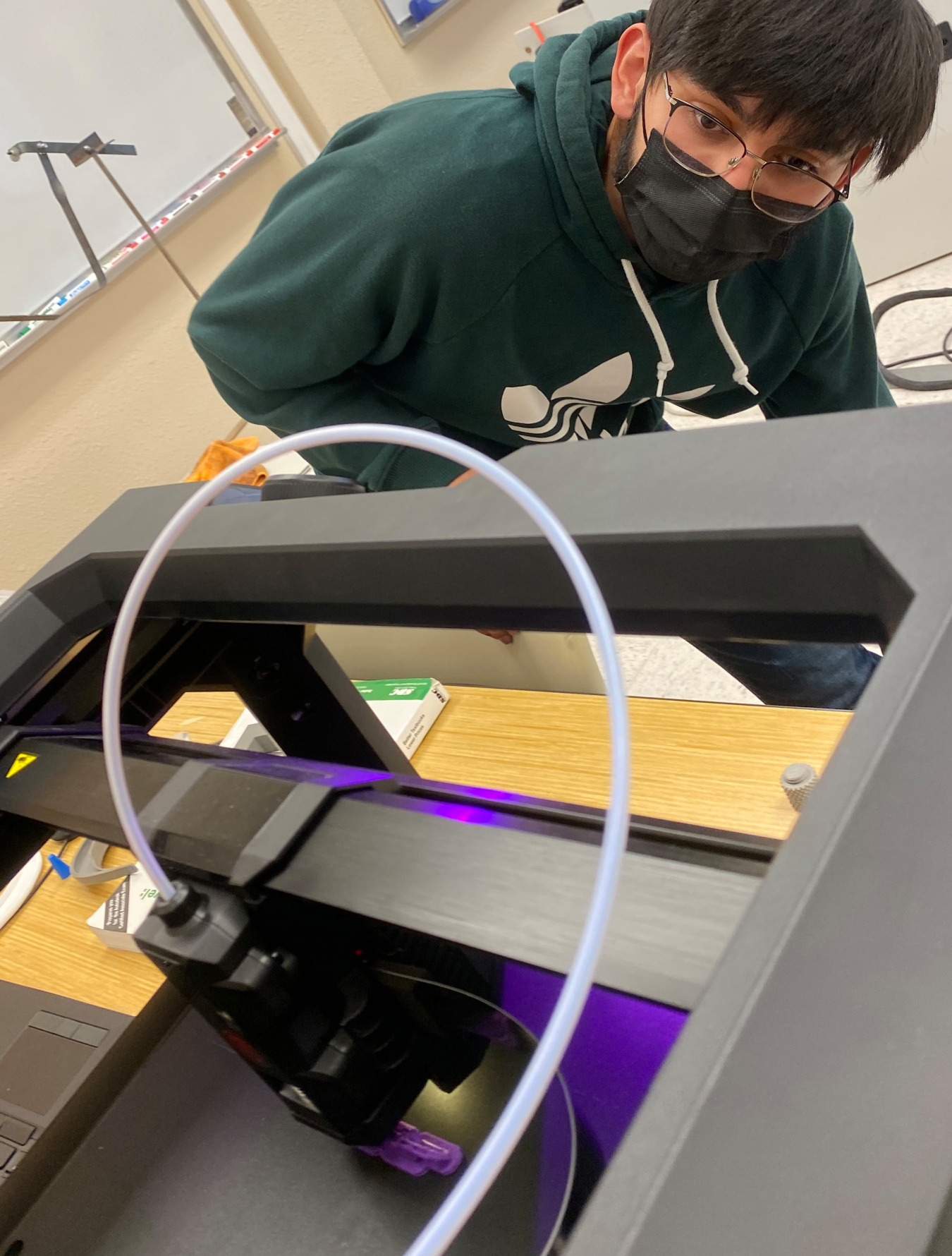 Engineering student Moises Trevino checks on the status of a chain being printed in the New Mexico State University Carlsbad engineering laboratory.