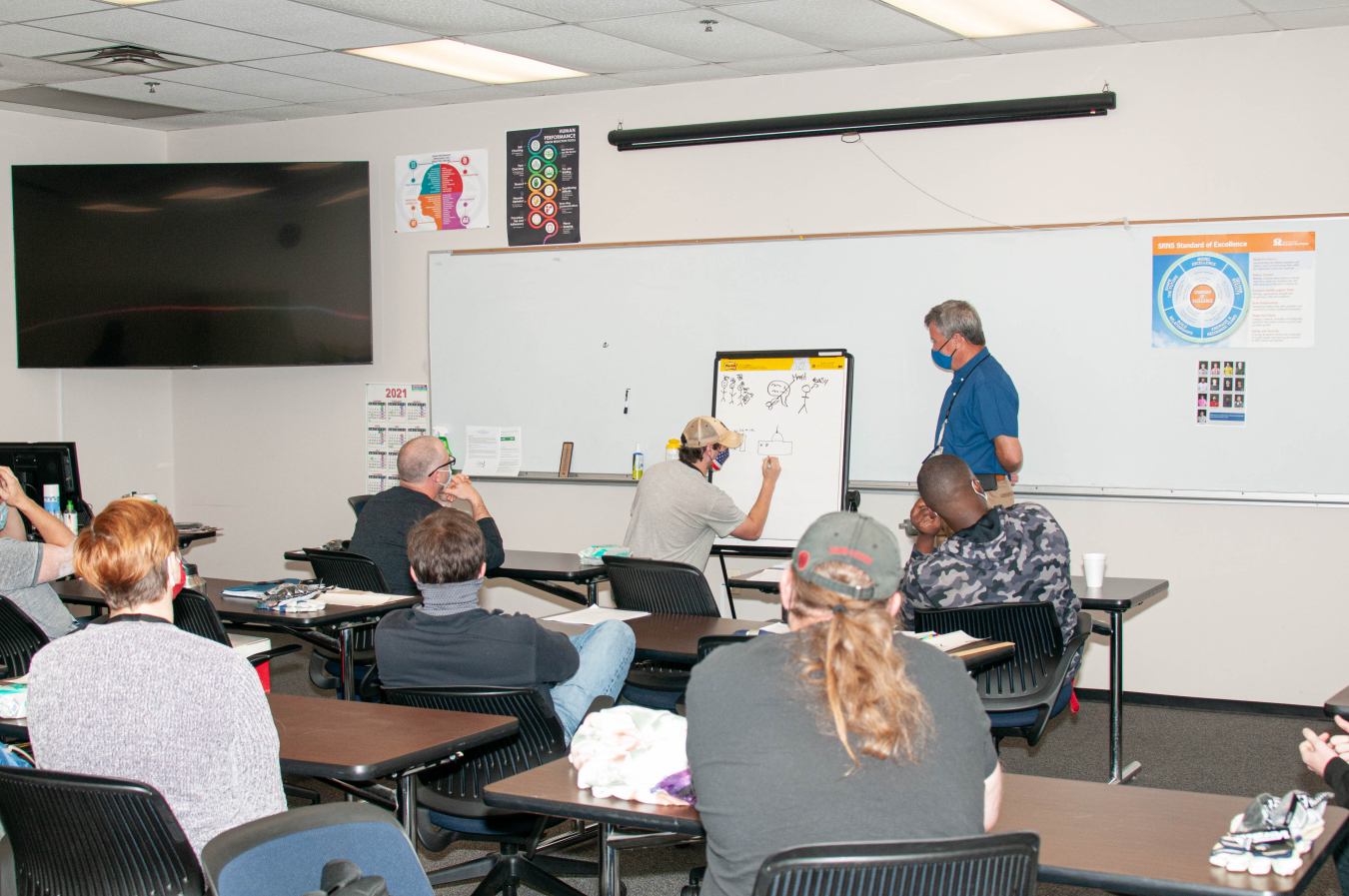 Production Operator Apprentice Brandon Richardson participates in a dynamic learning activity at the human performance improvement lab at the Savannah River Site. Conduct of Operations Program Manager Daryl Smoldt is to the right of Richardson.