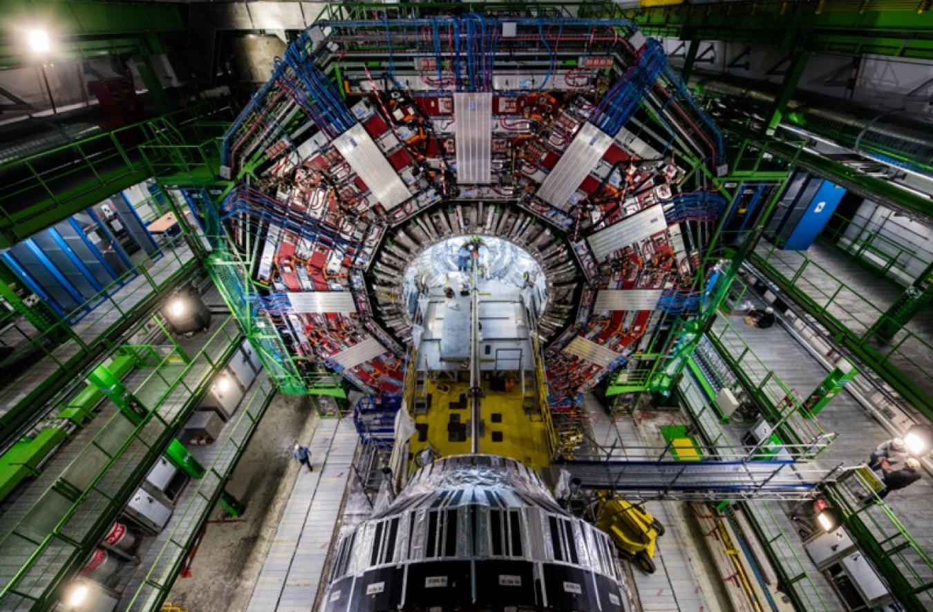 Aerial view of the Large Hadron Collider, a huge machine with a giant ring surrounded by balconies and scaffolding