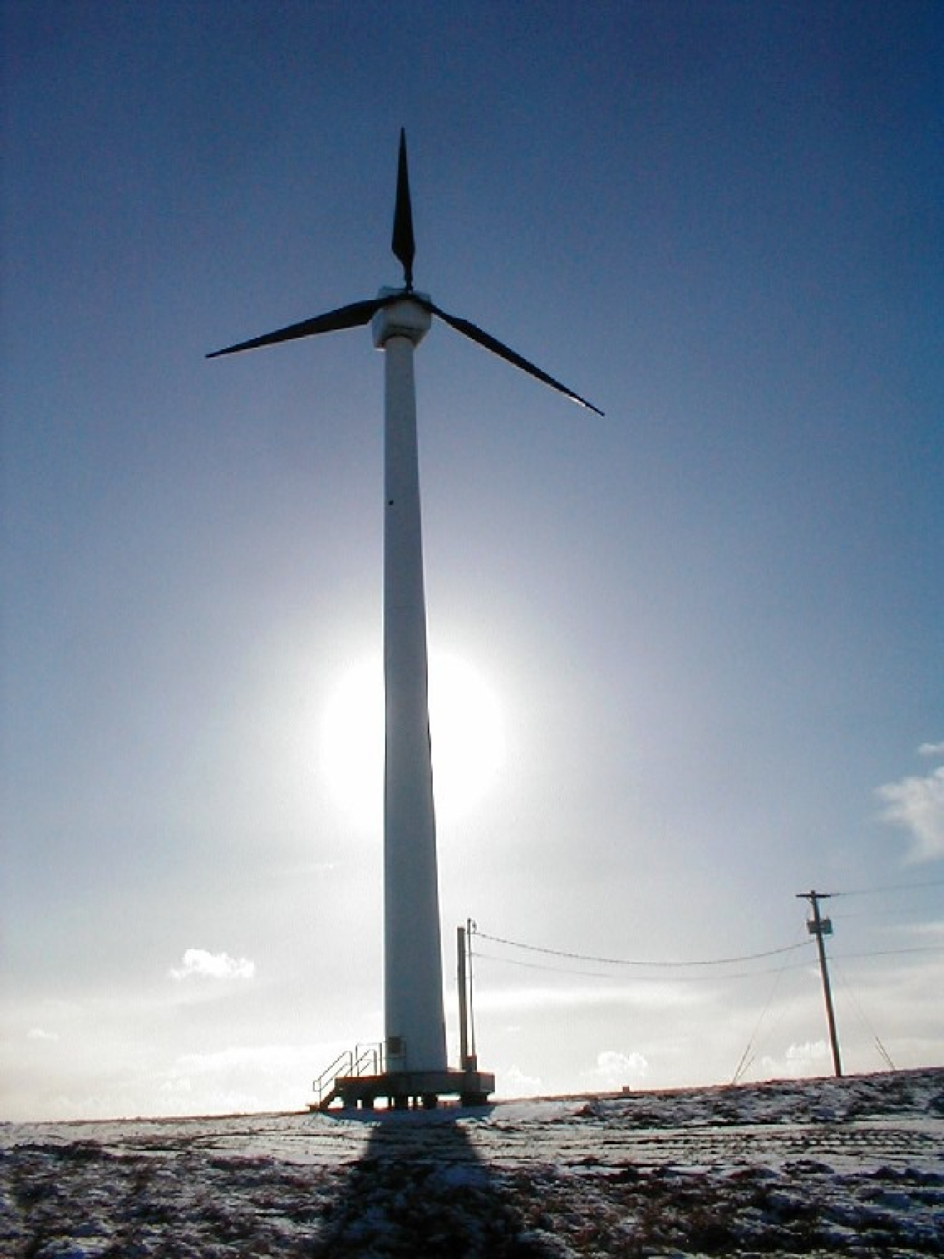 The sun shines on a distributed wind turbine in Toksook Bay, Alaska. DOE’s Phase I SBIR awards will help support new technologies that can reduce costs and improve performance of these smaller wind turbines.