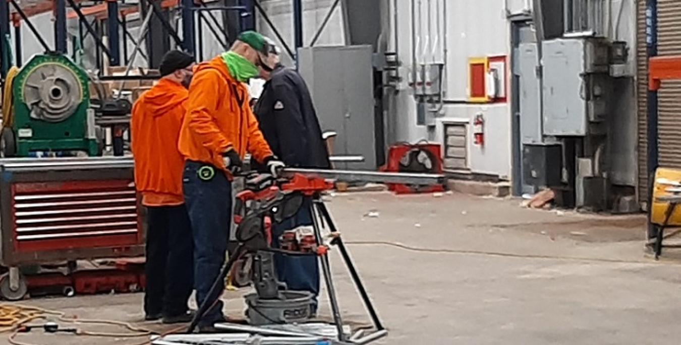 From left, electricians Chris Peck, Chris Bottoms, and Greg Cash work on modifications to relocate personnel and operations from 129,800 square feet of space in the C-720 Maintenance and Storage Building into a smaller facility.