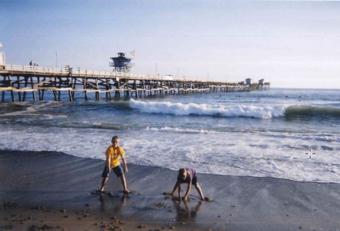 Two kids play on the beach.