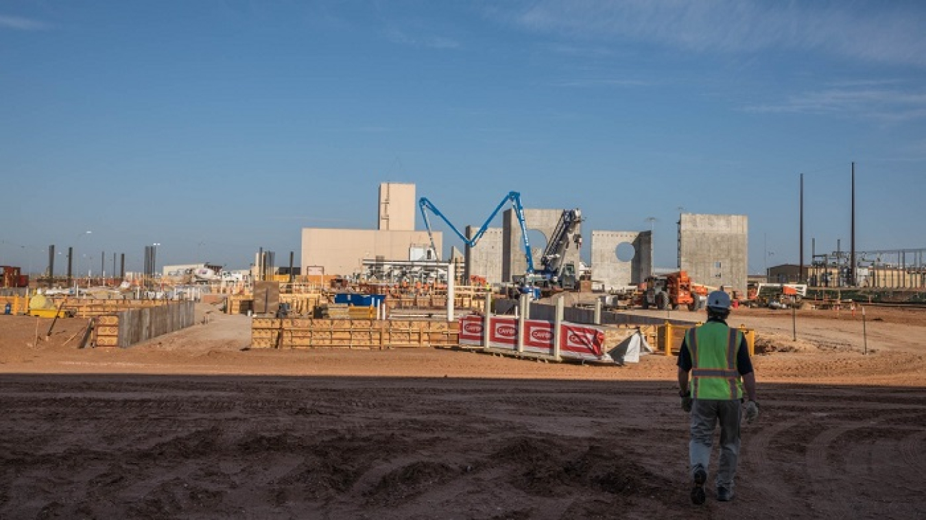 The long arm of a concrete truck reaches across to the site of the New Filter Building to lay another part of the slab foundation for the Safety Significant Confinement Ventilation System at the Waste Isolation Pilot Plant.