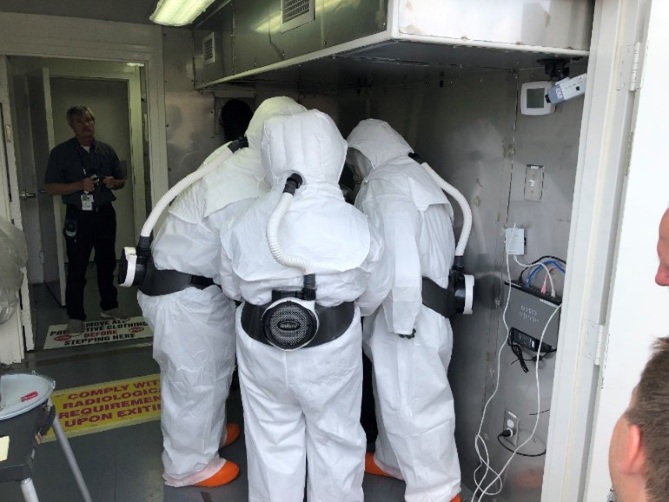 Mobile Plutonium Facility radiation safety technicians repackaging simulated material.