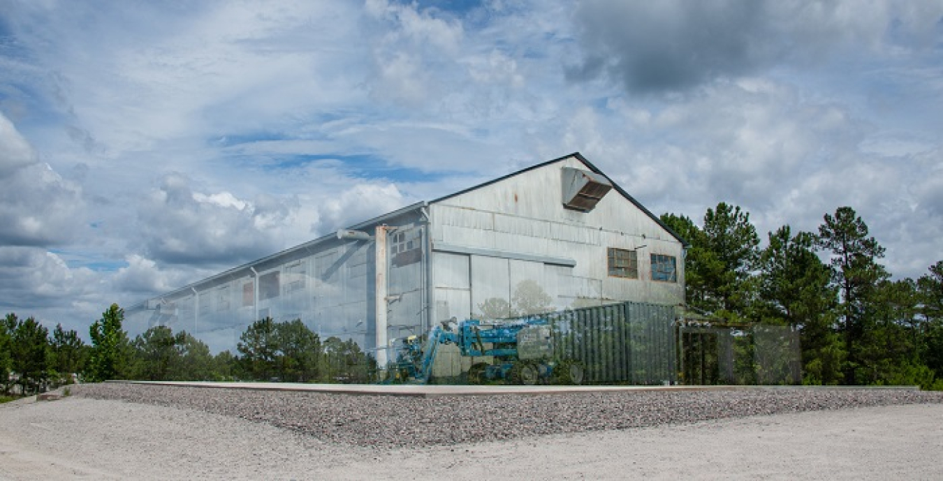 All that remains of the Ford Building at the Savannah River Site is a new six-inch concrete cap over its original foundation, marking the official closure of the deactivation and decommissioning project. This graphic image merges two photos: one of the Ford Building and one of the empty space where the building once stood.