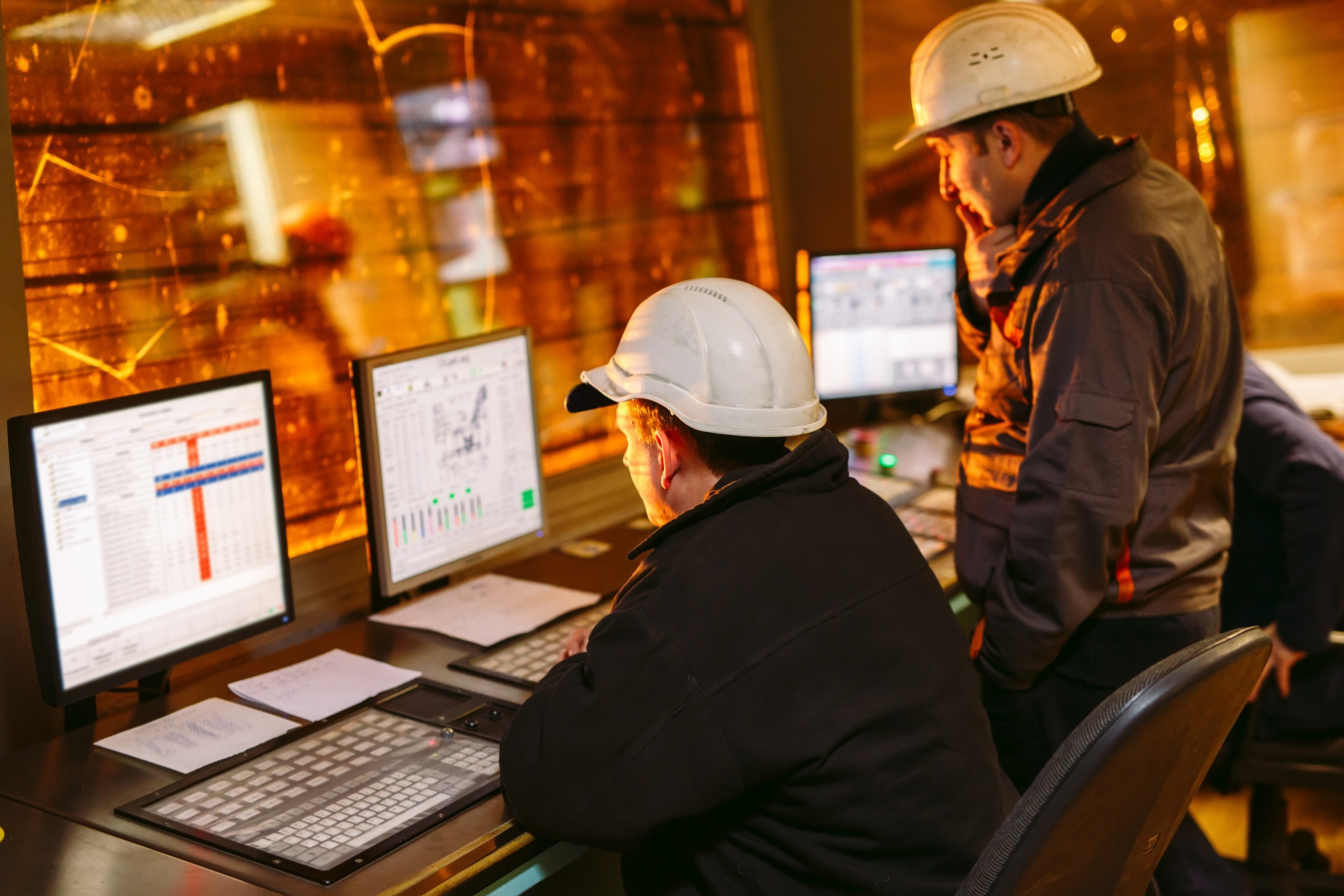 two people working on computers in a manufacturing facility