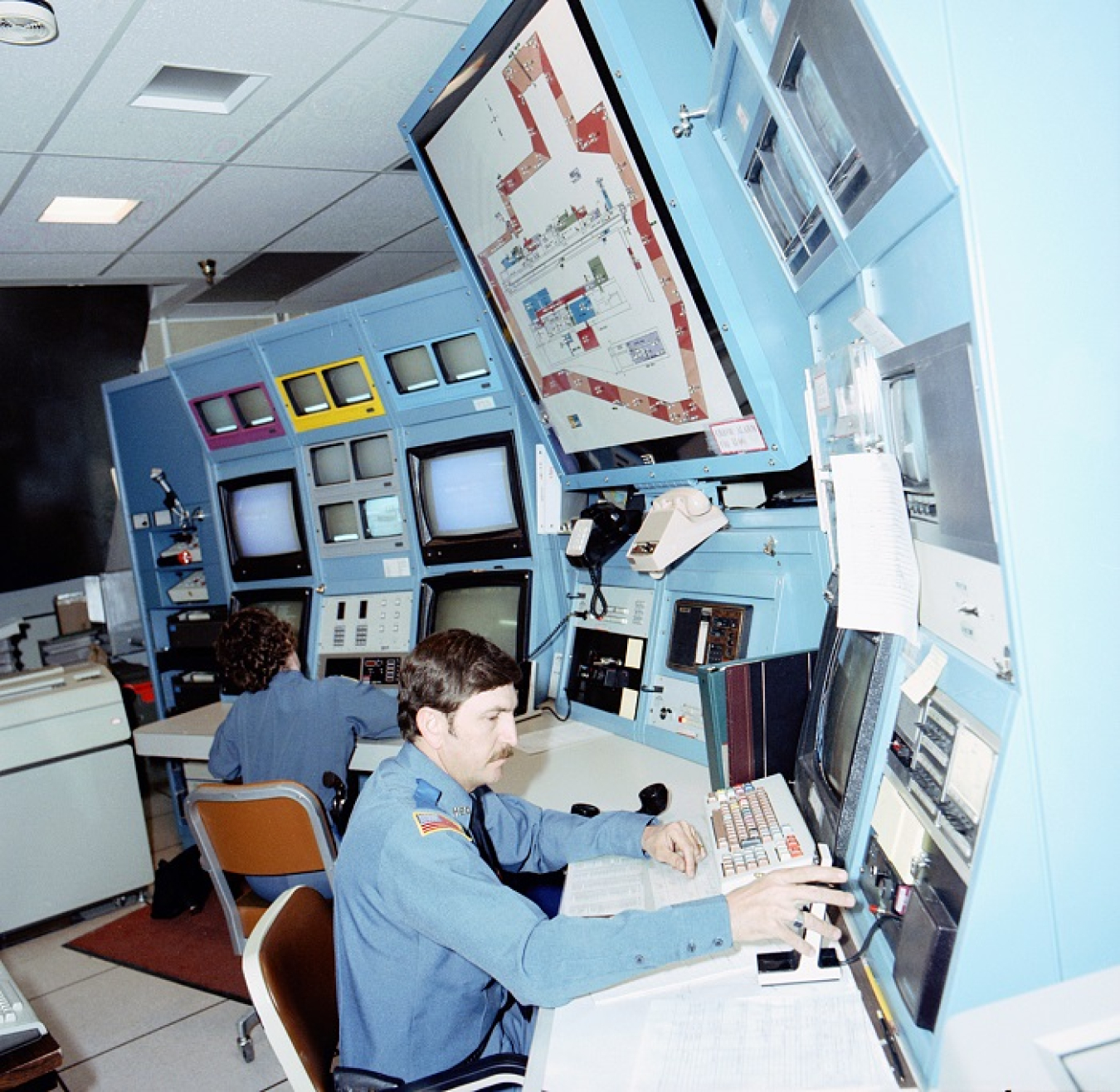 Security guards work at the Plutonium-Uranium Extraction Plant guard house during plutonium production operations. The former security checkpoint was recently demolished as part of ongoing risk-reduction activities near the former processing plant.