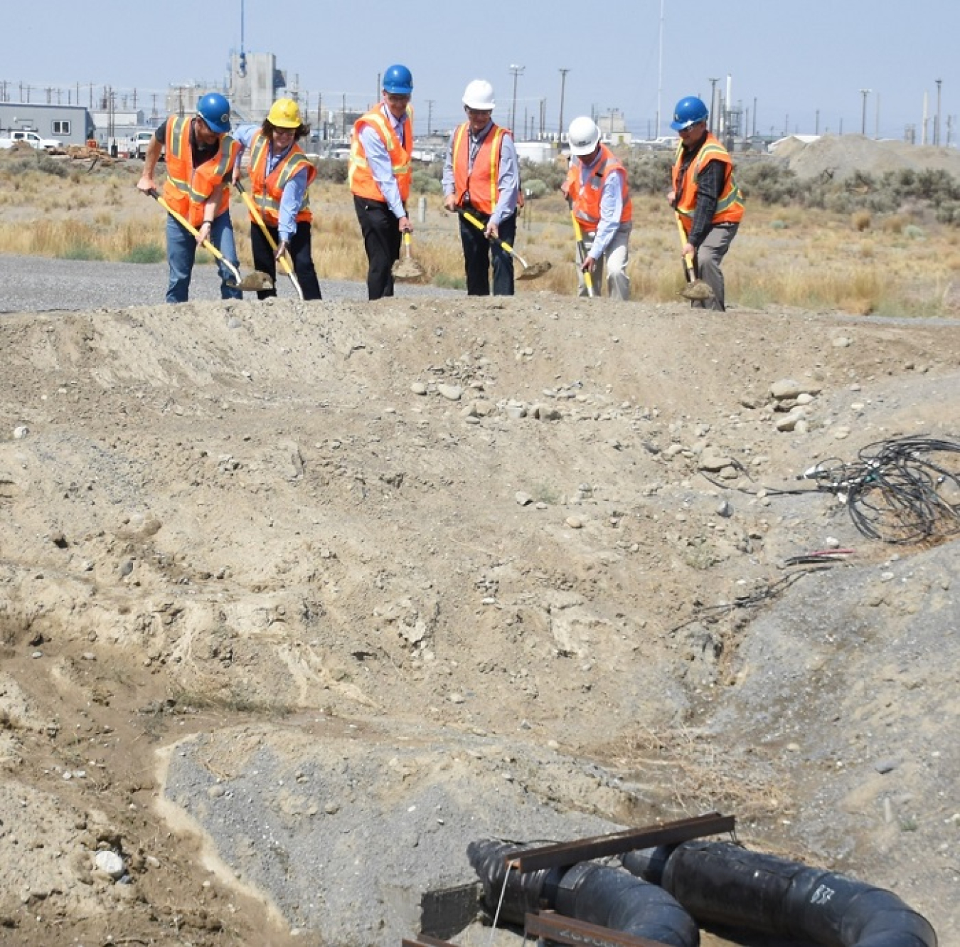 Hanford Site leadership take part in a celebratory filling-in of a trench containing a 3,500-foot piping system that connects a tank farm to the Waste Treatment and Immobilization Plant (WTP). From left, Tom Fletcher, WTP operations, Office of River Protection (ORP); Val McCain, Vitrification Plant project director, Bechtel National Inc.; Brian Vance, manager, ORP and Richland Operations Office; David Bowen, Nuclear Waste Program manager, Washington State Department of Ecology; John Eschenberg, president an