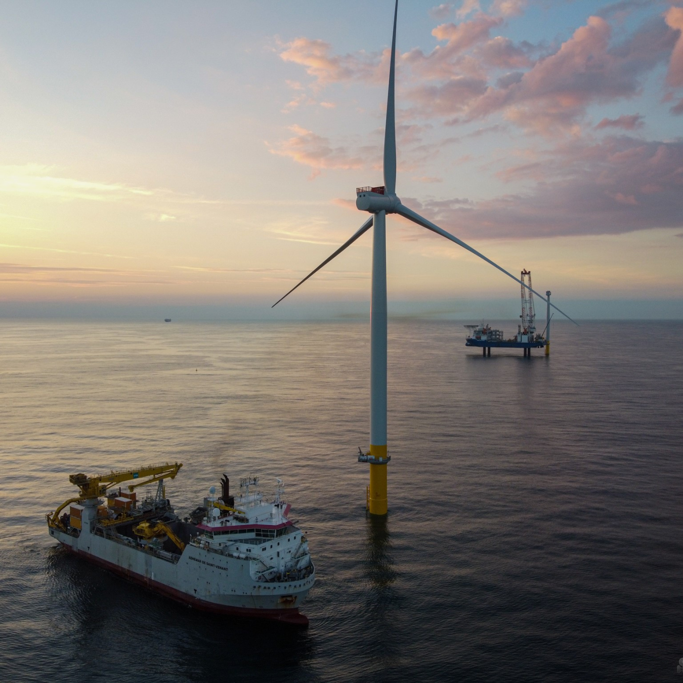 Offshore wind turbine and a boat at sea.