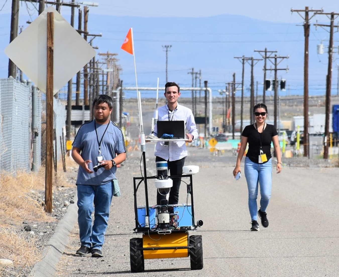 During a recent road closure on the Hanford Site, Florida International University students, from left, Jeff Natividad, Joel Adams, and Thi Tran, test a radiation mapping robot outside a tank farm. The students are part of a unique internship program between EM and the university.