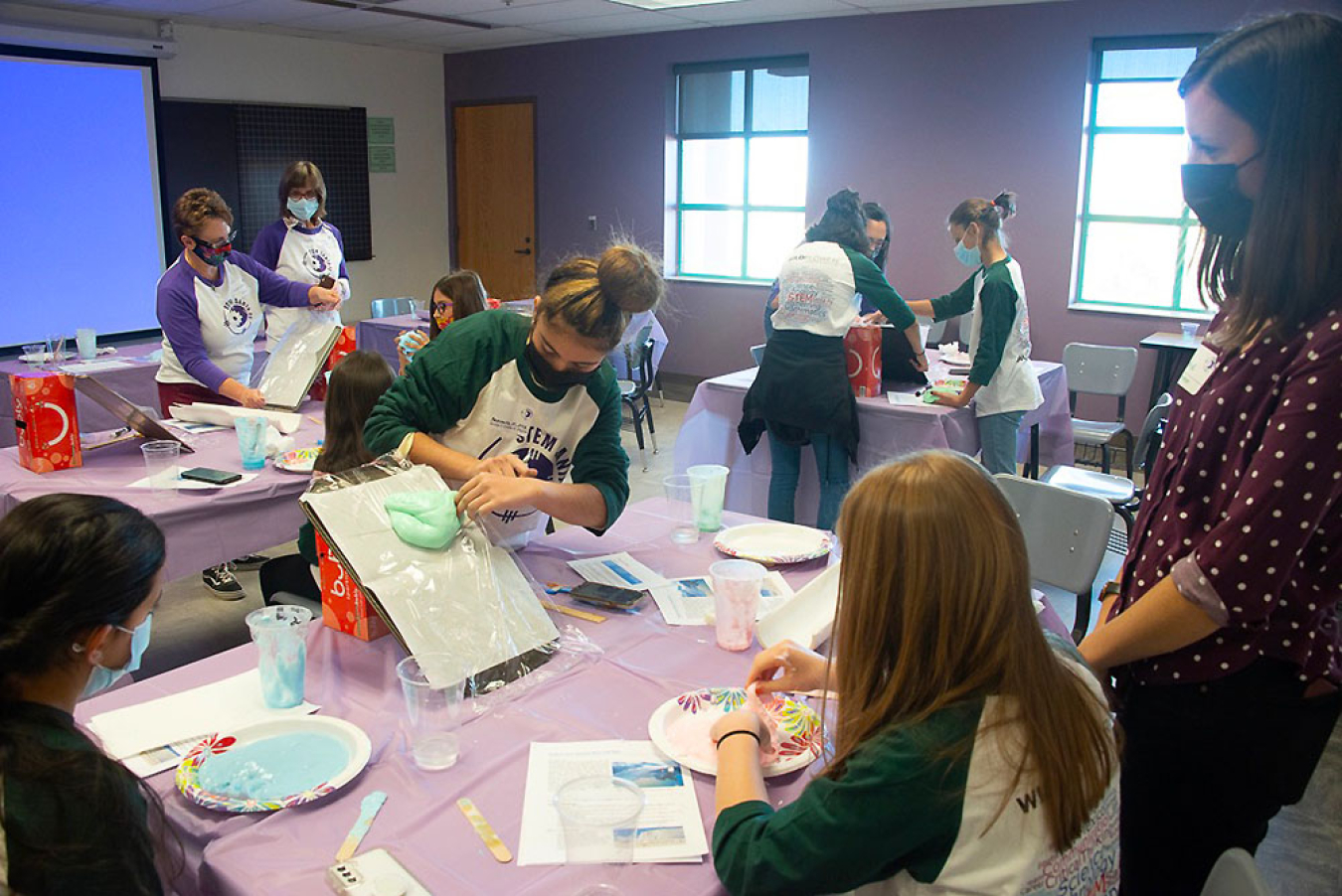 Attendees take part in the hands-on glacier activity led by Laboratory volunteers Elizabeth Hunke (at the back, second from left), and Sophie Coulson (on the far right).