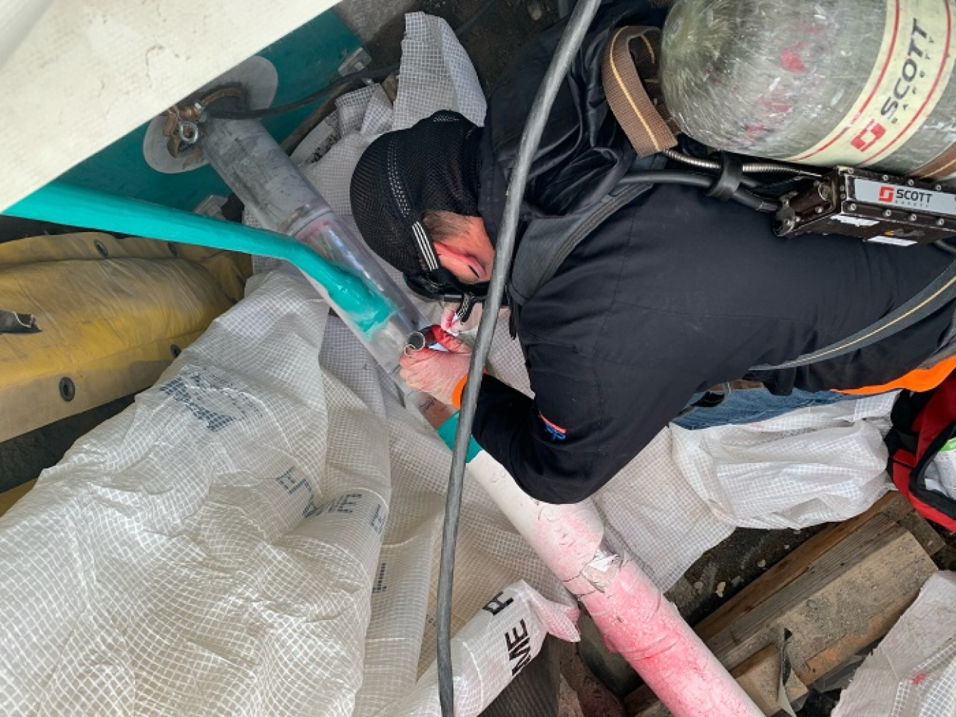 A worker installing new waste transfer lines between large, underground tanks and Hanford’s evaporator facility welds a secondary encasement on one of the lines.