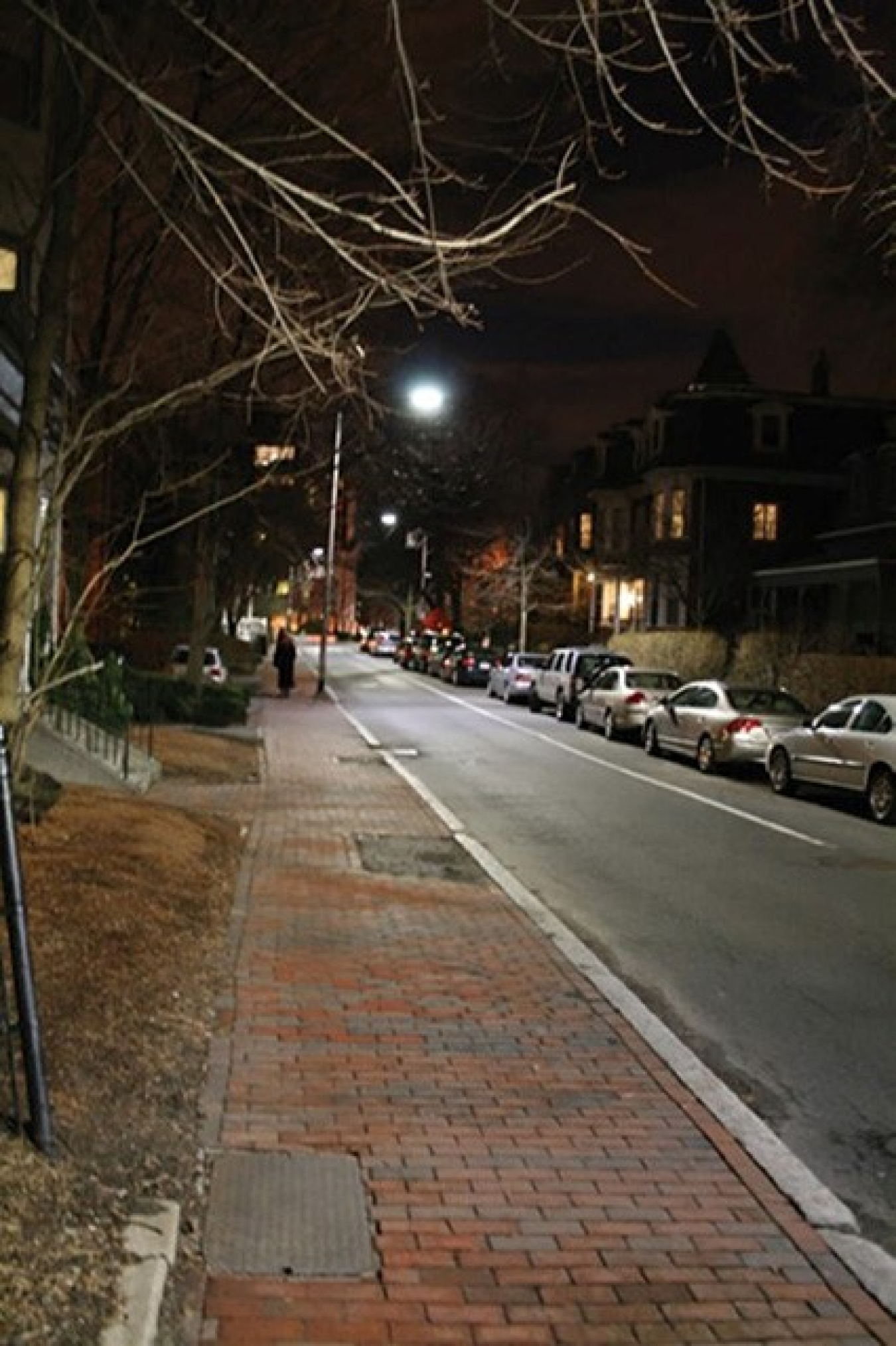 A city street at night with a lighted streetlight.